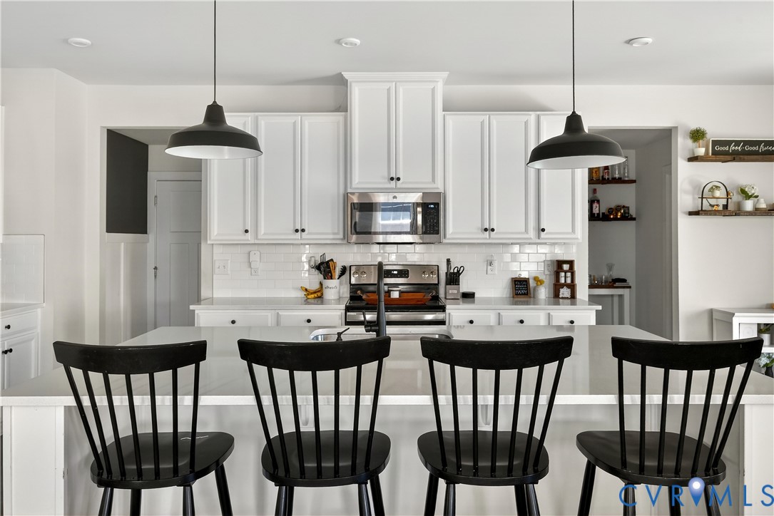 1618 Almer Lane Chester, VA 23836 - Photo 18 of 59 a kitchen with stainless steel appliances granite countertop a dining table chairs and a refrigerator