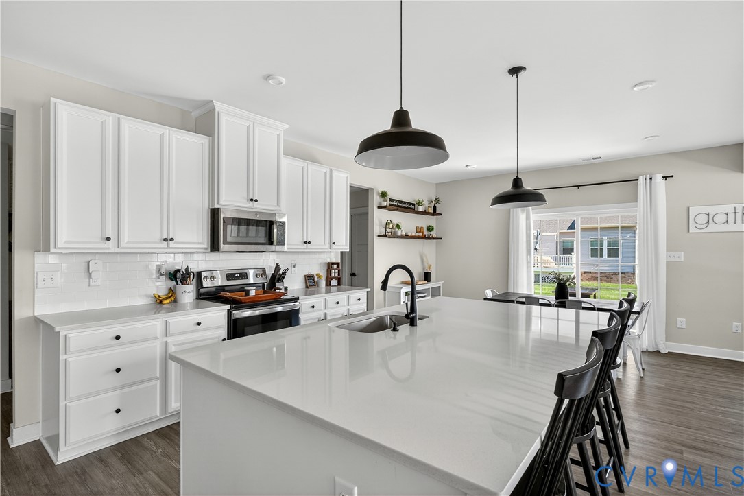 1618 Almer Lane Chester, VA 23836 - Photo 24 of 59 a kitchen with stainless steel appliances a table chairs and white cabinets