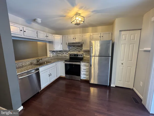 a kitchen with granite countertop stainless steel appliances a refrigerator a sink a stove a microwave and cabinets
