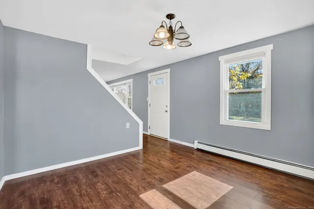 a view of a livingroom with wooden floor and a ceiling fan