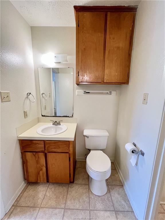 711 Vassar Court, Unit B College Station, TX 77840 - Photo 14 of 23 a bathroom with a toilet sink and mirror