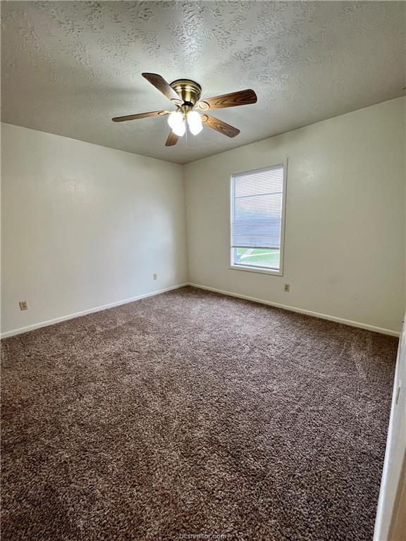 711 Vassar Court, Unit B College Station, TX 77840 - Photo 19 of 23 an empty room with windows and chandelier fan
