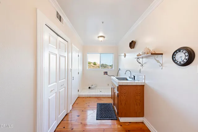 a hallway with painting on the wall and a mirror