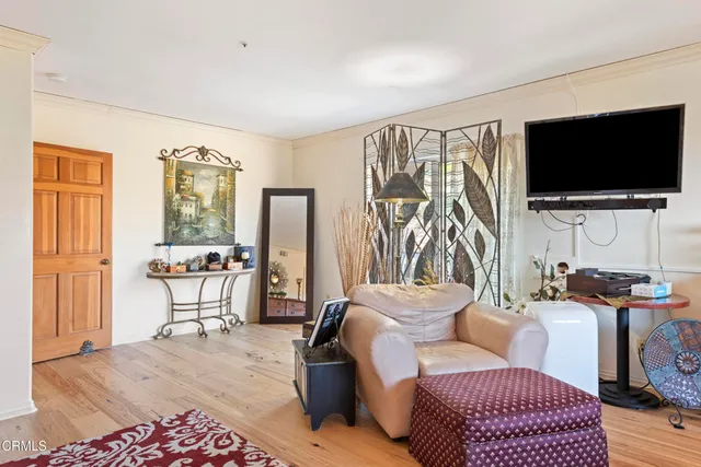 a living room with furniture a flat screen tv and a window