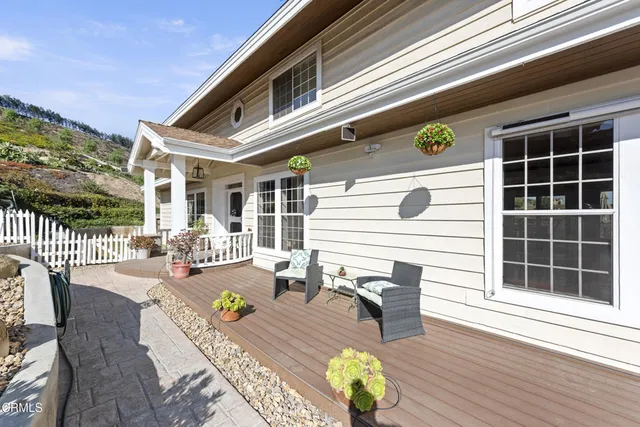 a view of a patio with couches chairs and wooden floor