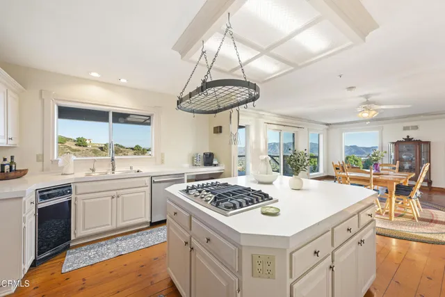 a kitchen with a stove a table and chairs in it