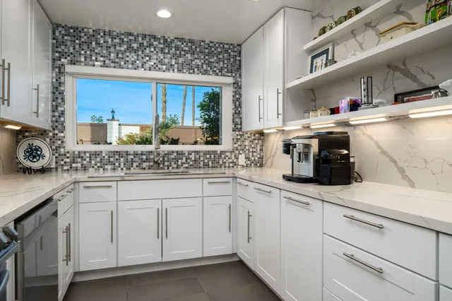 a kitchen with stainless steel appliances granite countertop a sink and a window
