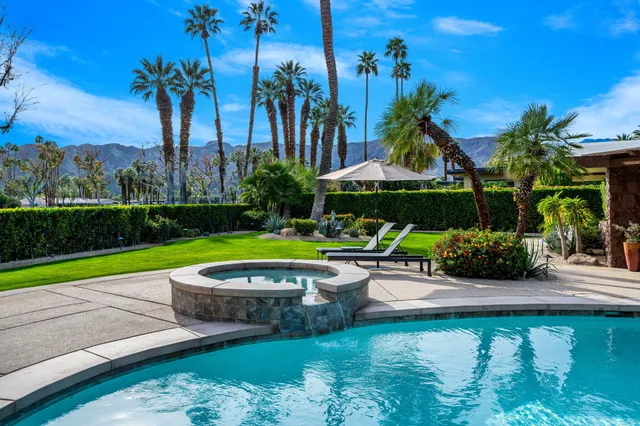 a view of a patio with a table and chairs under an umbrella