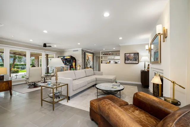 a living room with furniture a rug and a view of kitchen
