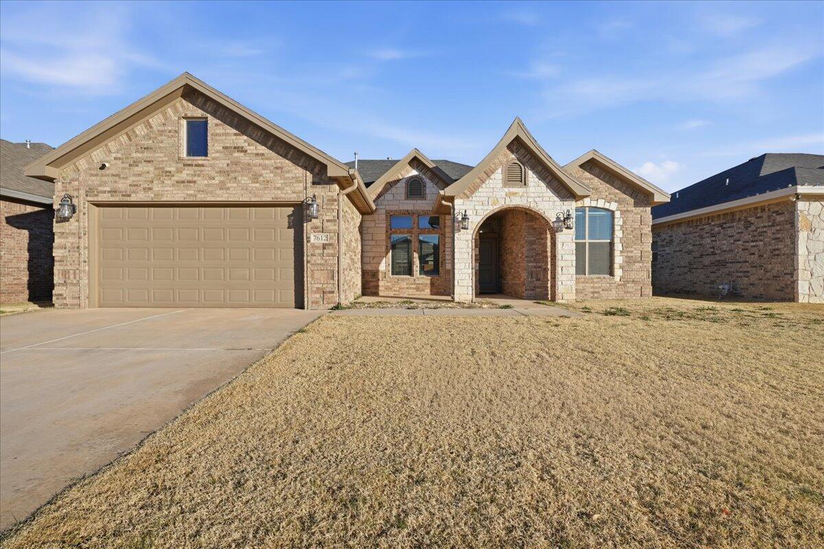 7612 59th Street Lubbock, TX 79407 - Photo 1 of 42 a front view of a house with a yard and garage