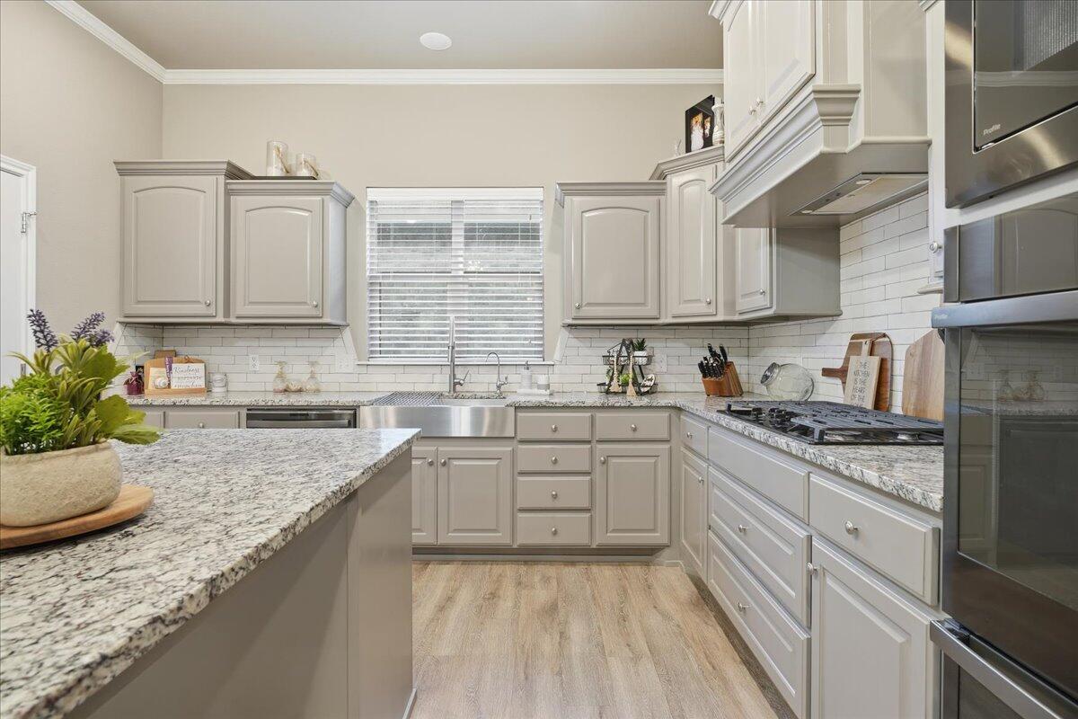 7612 59th Street Lubbock, TX 79407 - Photo 14 of 42 a kitchen with granite countertop cabinets stainless steel appliances and a sink