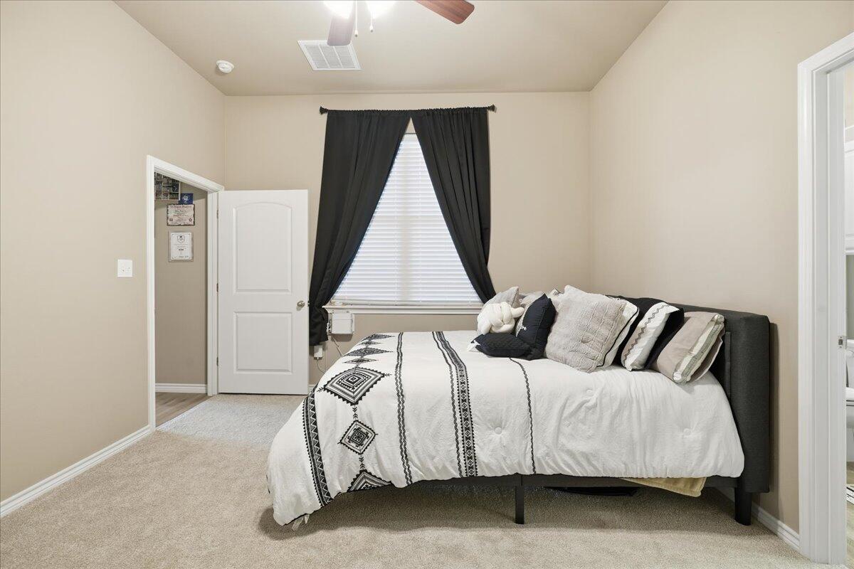 7612 59th Street Lubbock, TX 79407 - Photo 19 of 42 a bed sitting in a bedroom next to a window