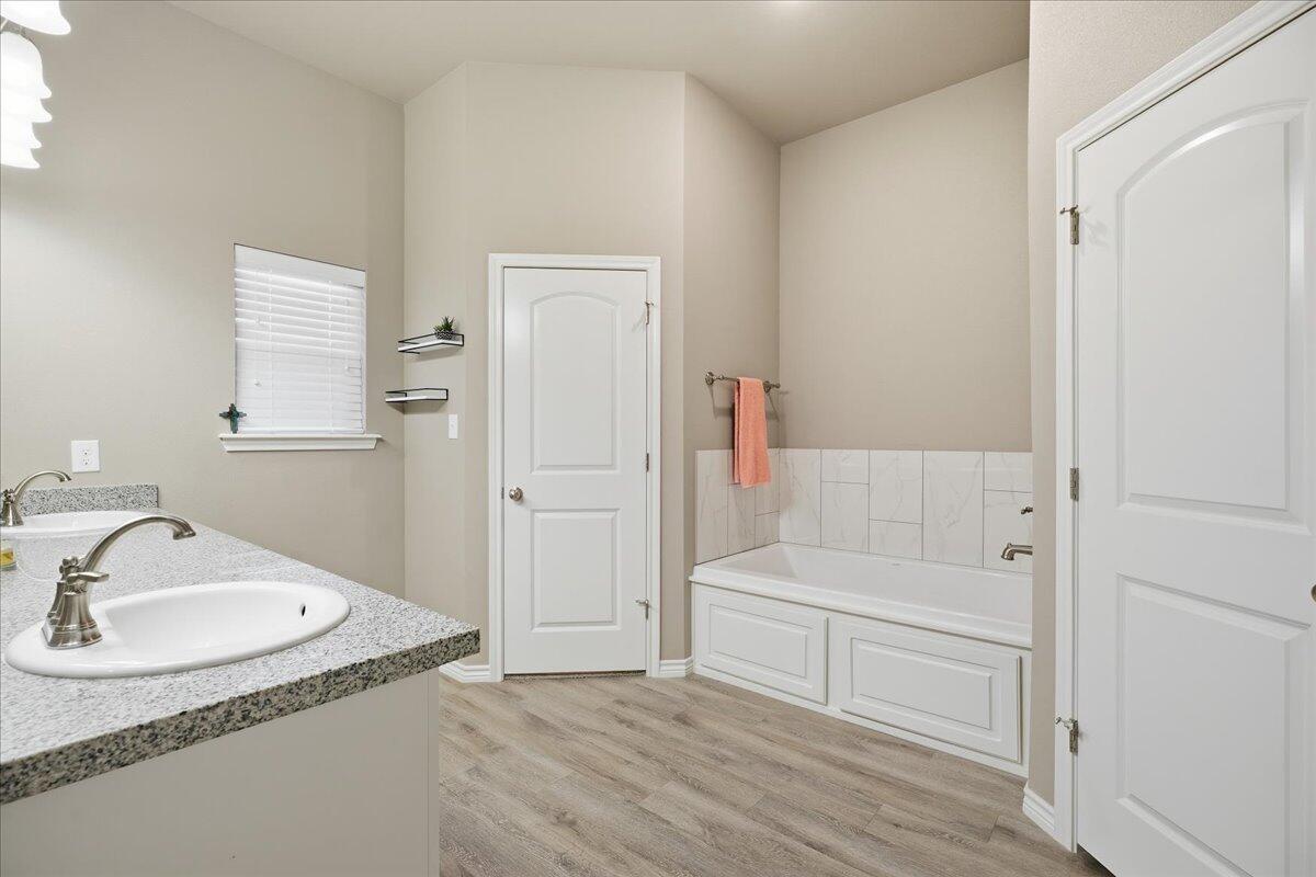 7612 59th Street Lubbock, TX 79407 - Photo 26 of 42 a bathroom with a bathtub and a sink