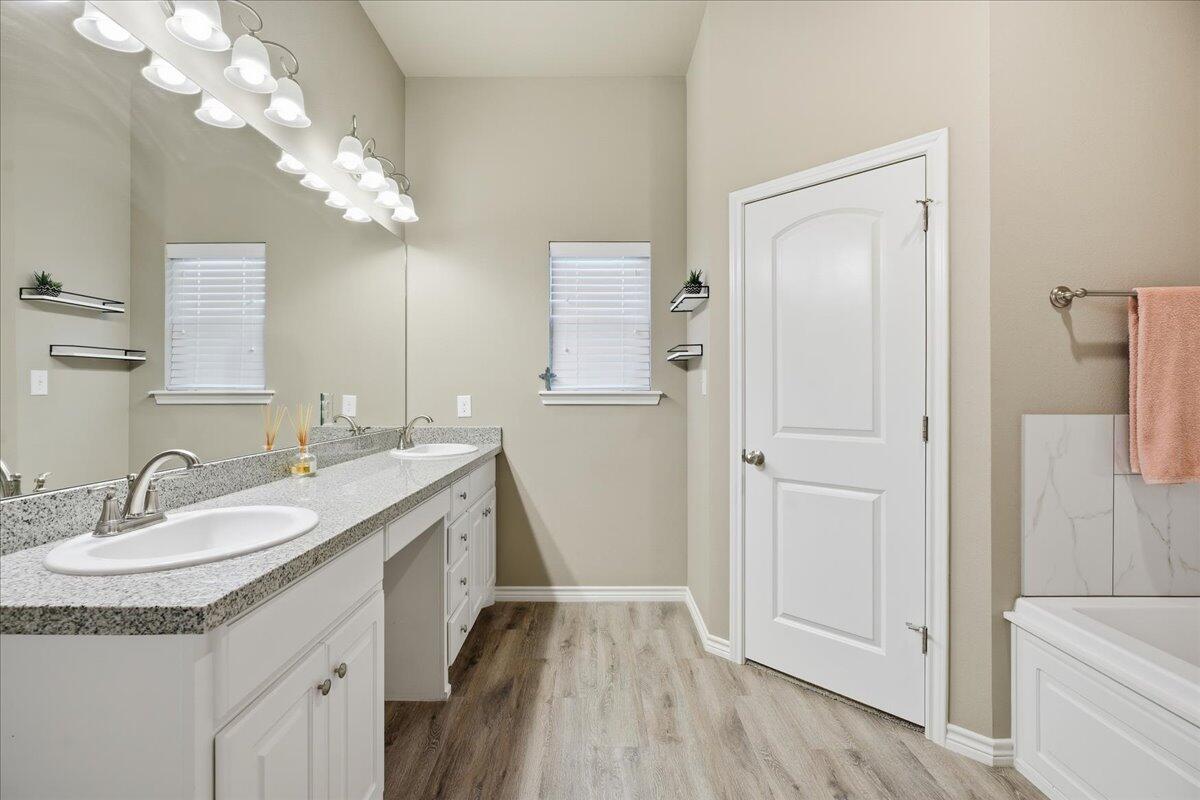 7612 59th Street Lubbock, TX 79407 - Photo 27 of 42 a bathroom with a sink a vanity and a mirror