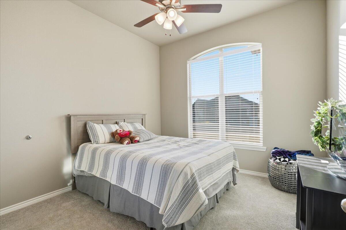 7612 59th Street Lubbock, TX 79407 - Photo 32 of 42 a bedroom with a bed and a chandelier