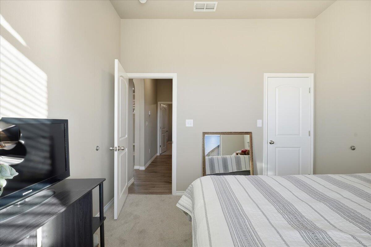 7612 59th Street Lubbock, TX 79407 - Photo 33 of 42 a bedroom with a bed and a flat tv screen