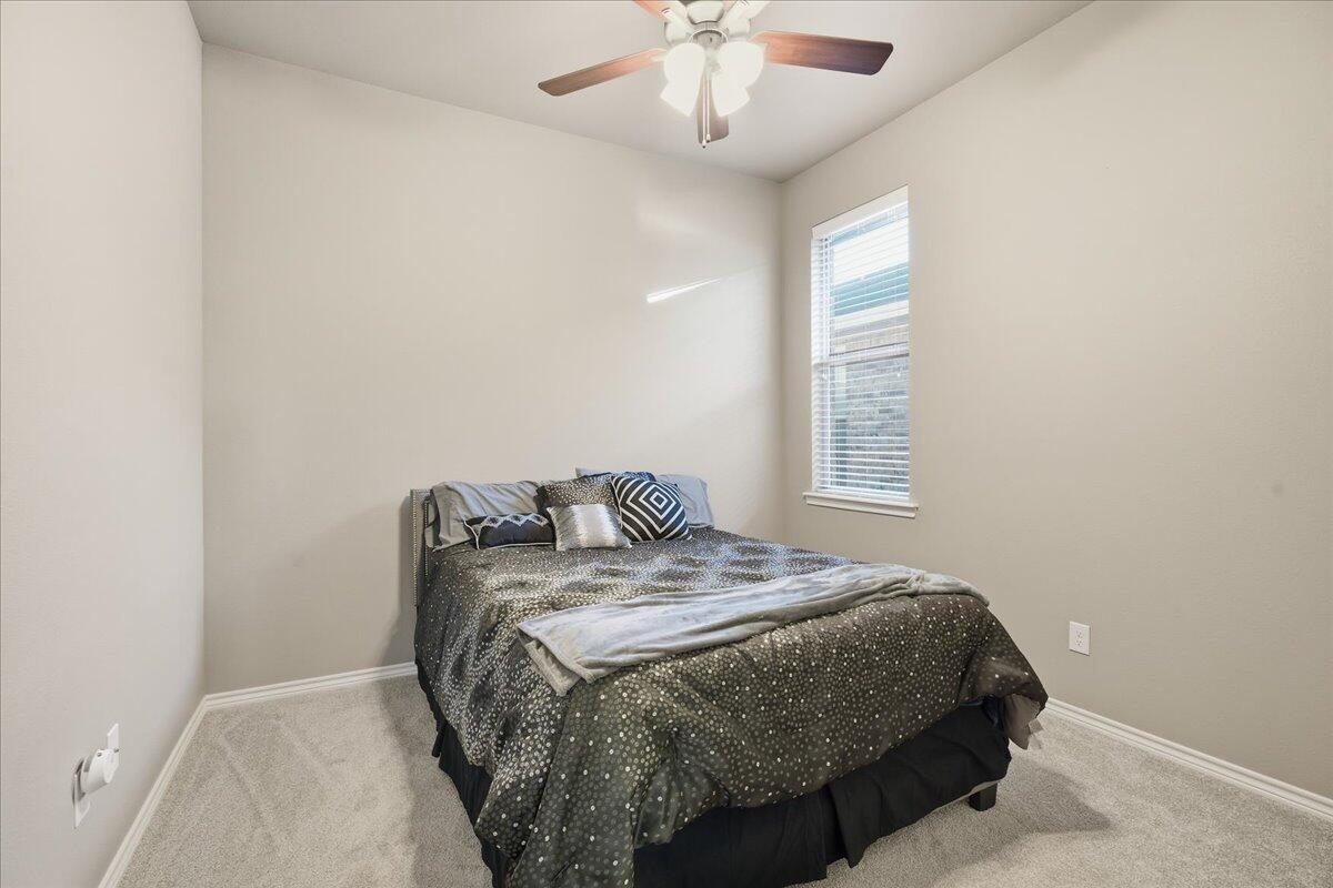 7612 59th Street Lubbock, TX 79407 - Photo 34 of 42 a bedroom with a bed and a chandelier
