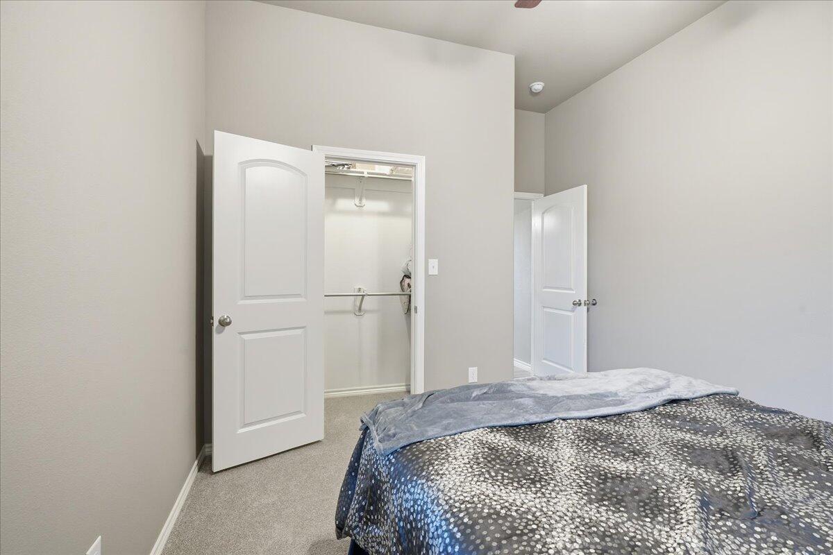 7612 59th Street Lubbock, TX 79407 - Photo 35 of 42 a bedroom with a bed and a bathroom