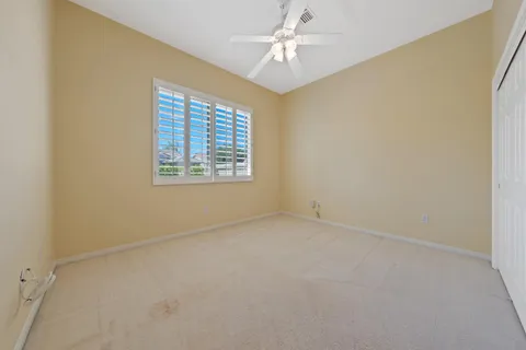 an empty room with a window and a fan
