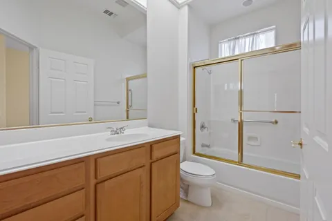 a bathroom with a granite countertop sink toilet a mirror and shower