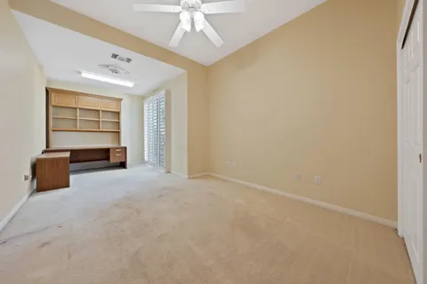 an empty room with windows and cabinet