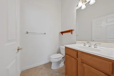 a bathroom with a granite countertop sink a toilet and a mirror