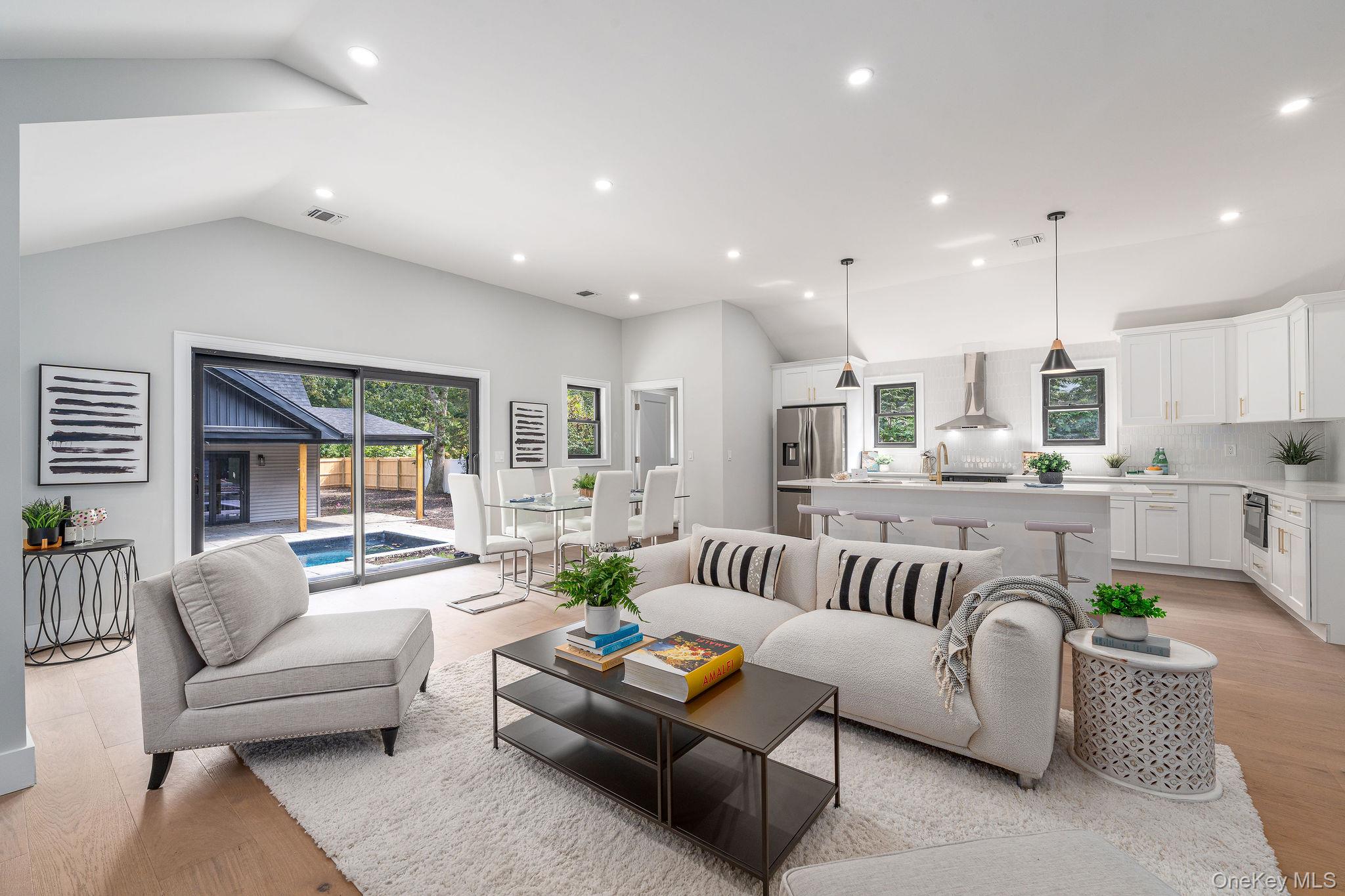 Living area with light wood-style flooring, recessed lighting, and lofted ceiling