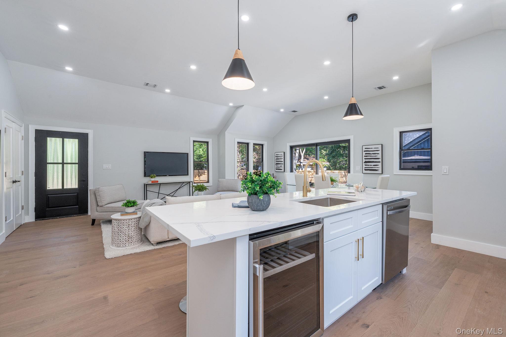 3420 Rocky Point Road East Marion, NY 11939 - Photo 11 of 34 Kitchen with light stone countertops, light wood-type flooring, beverage cooler, lofted ceiling, and recessed lighting