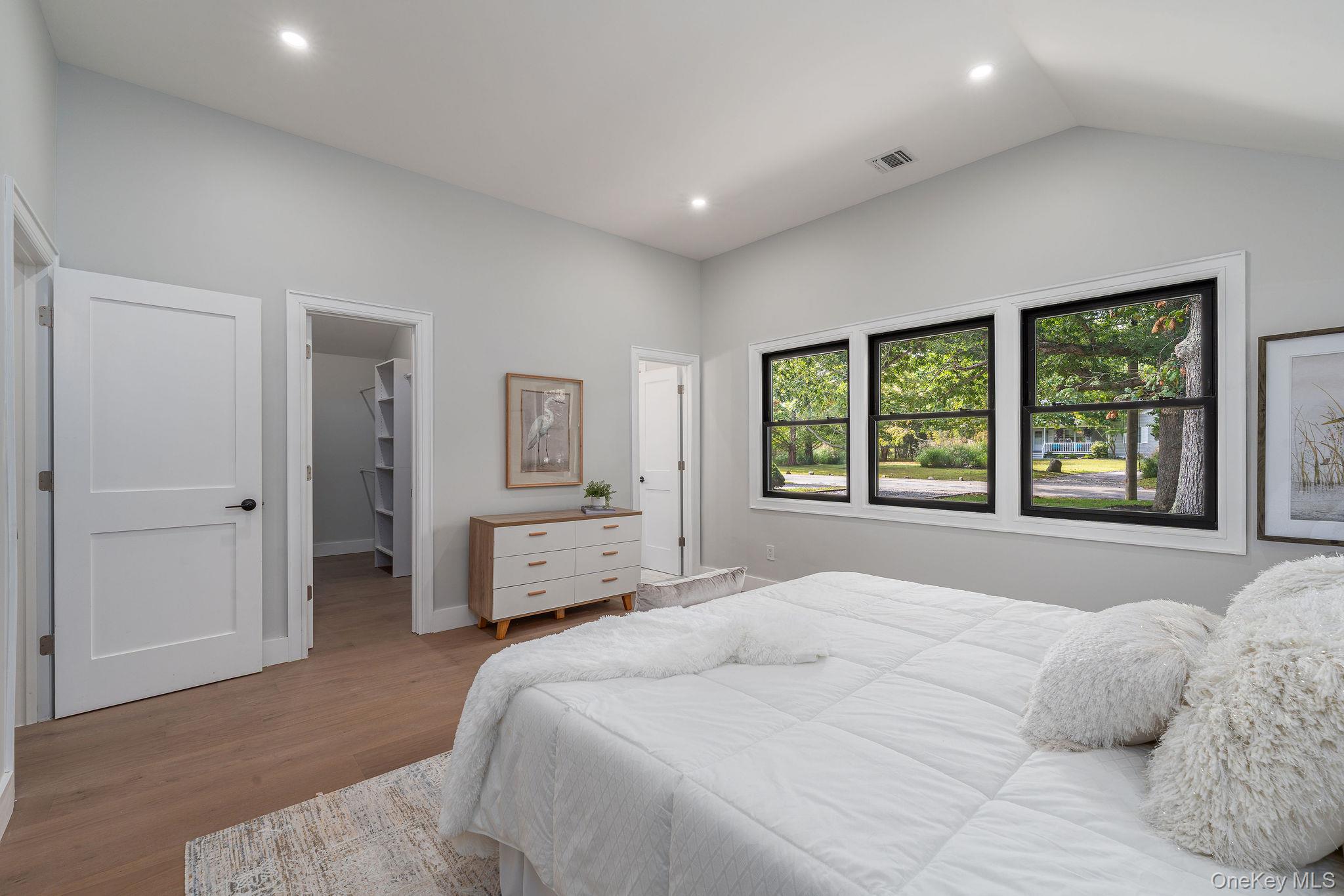 3420 Rocky Point Road East Marion, NY 11939 - Photo 15 of 34 Bedroom featuring a spacious closet, wood finished floors, recessed lighting, and vaulted ceiling