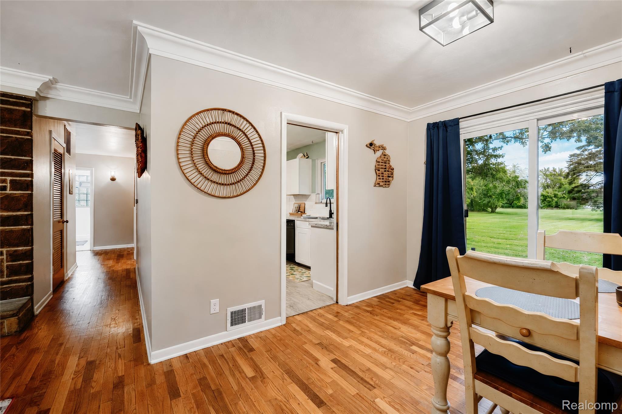 4499 South Linden Road Flint, MI 48507 - Photo 11 of 36 Hardwood flooring, crown molding, sliding glass door, recessed ceiling light, and stone accent wall