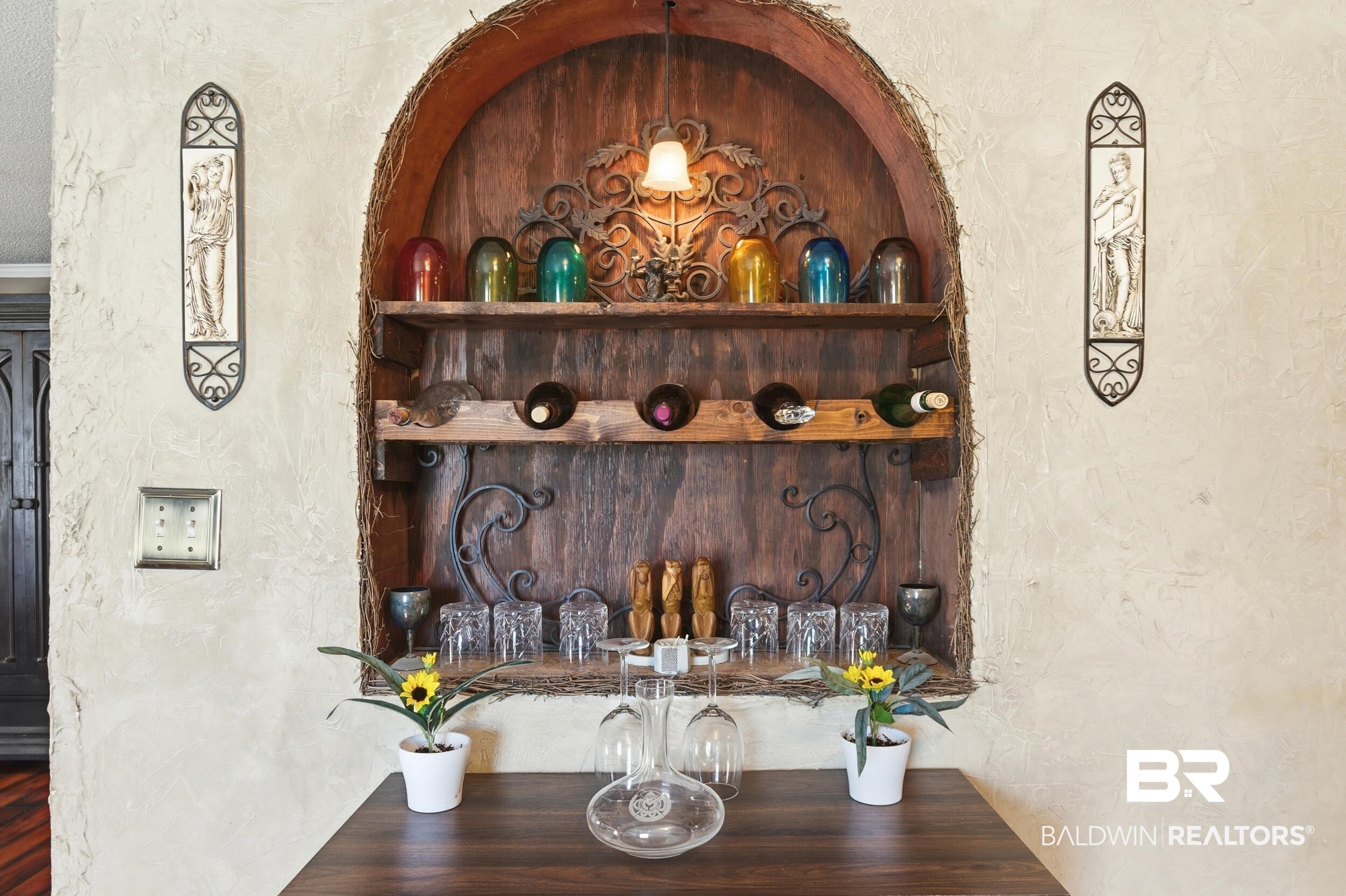 51620 Robert White Road Bay Minette, AL 36507 - Photo 27 of 81 Arched built-in display niche with rustic wood shelves, integrated bottle storage, and decorative wrought iron accents