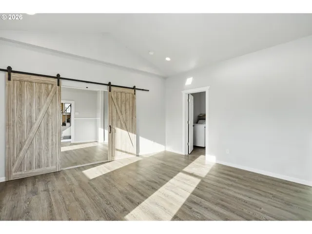 a view of an empty room with wooden floor