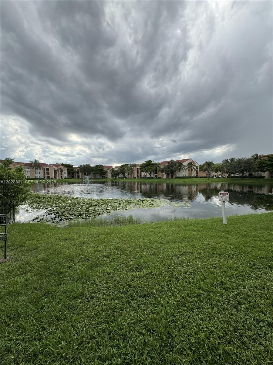 2021 Renaissance Boulevard, Unit 201 Miramar, FL 33025 - Photo 24 of 26 a view of a lake with houses in the back