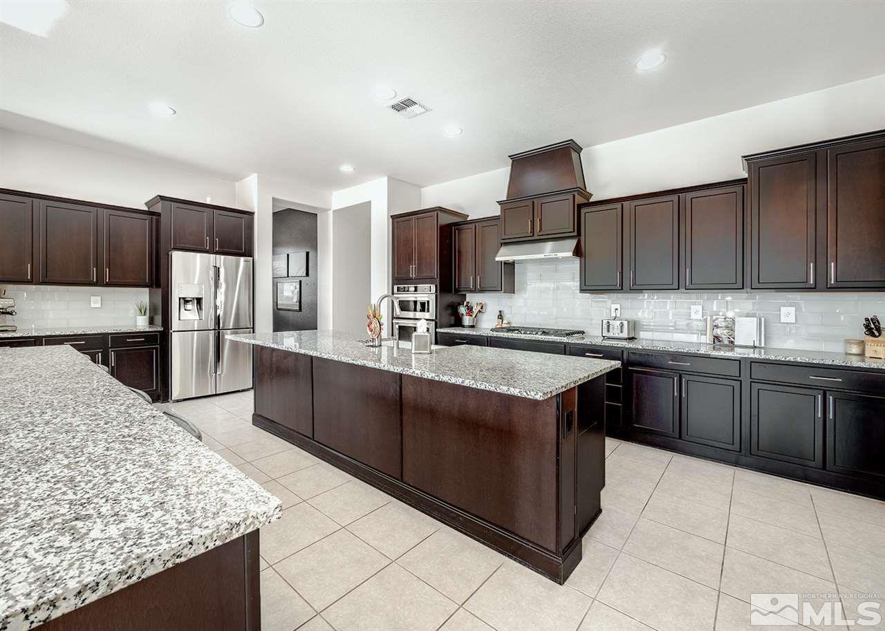 2930 Arroch Way Reno, NV 89521 - Photo 3 of 26 a kitchen with stainless steel appliances kitchen island granite countertop a sink counter space and cabinets