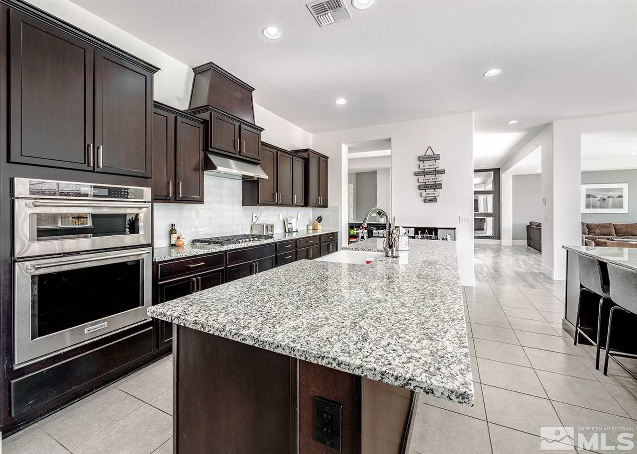 2930 Arroch Way Reno, NV 89521 - Photo 4 of 26 a kitchen with stainless steel appliances granite countertop a stove oven and a refrigerator