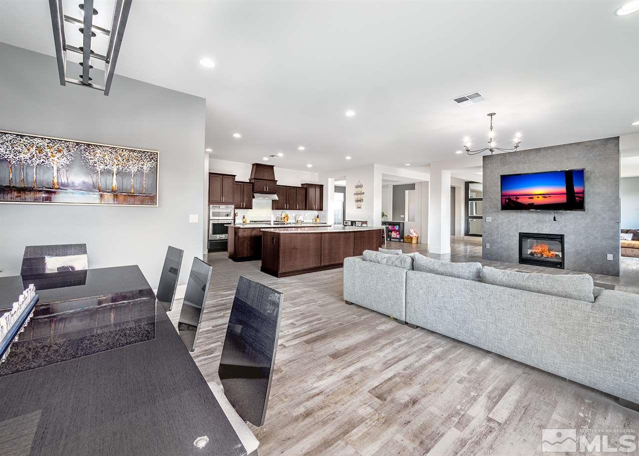 2930 Arroch Way Reno, NV 89521 - Photo 8 of 26 a living room with furniture a fireplace kitchen view and a flat screen tv