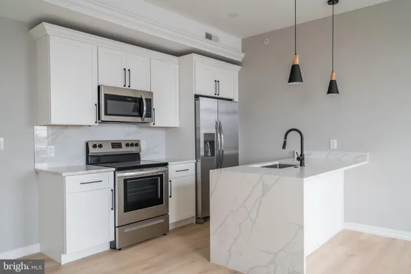 a kitchen with stainless steel appliances a stove a sink a microwave and cabinets