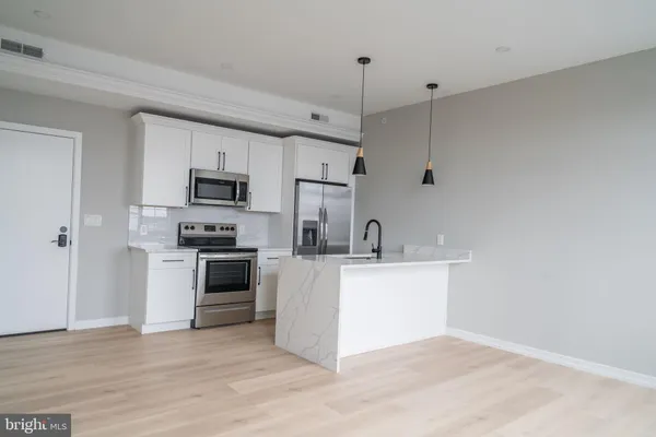 a kitchen with kitchen island white cabinets and stainless steel appliances