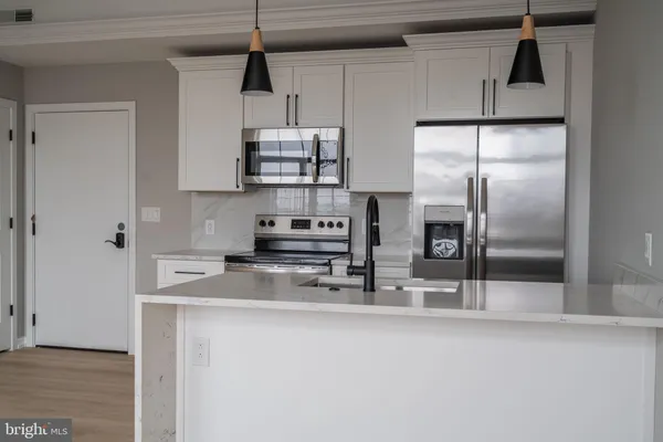 a kitchen with stainless steel appliances granite countertop a sink a refrigerator and a granite counter tops