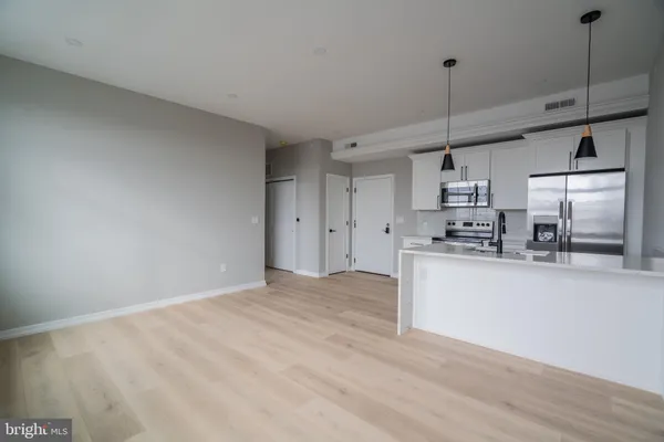 a view of kitchen with stainless steel appliances granite countertop cabinets and wooden floor