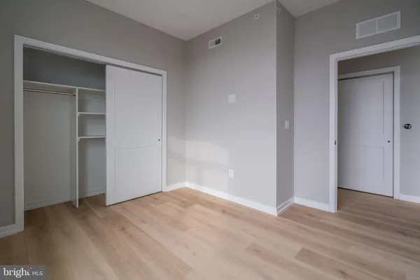 a view of empty room with wooden floor