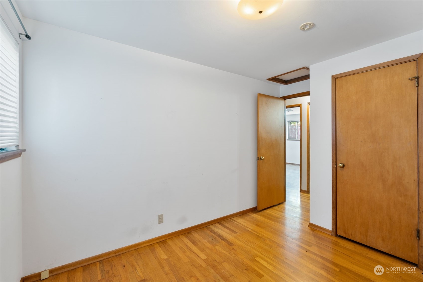 7634 South 112th Street Seattle, WA 98178 - Photo 12 of 26 a view of an empty room with wooden floor and a window