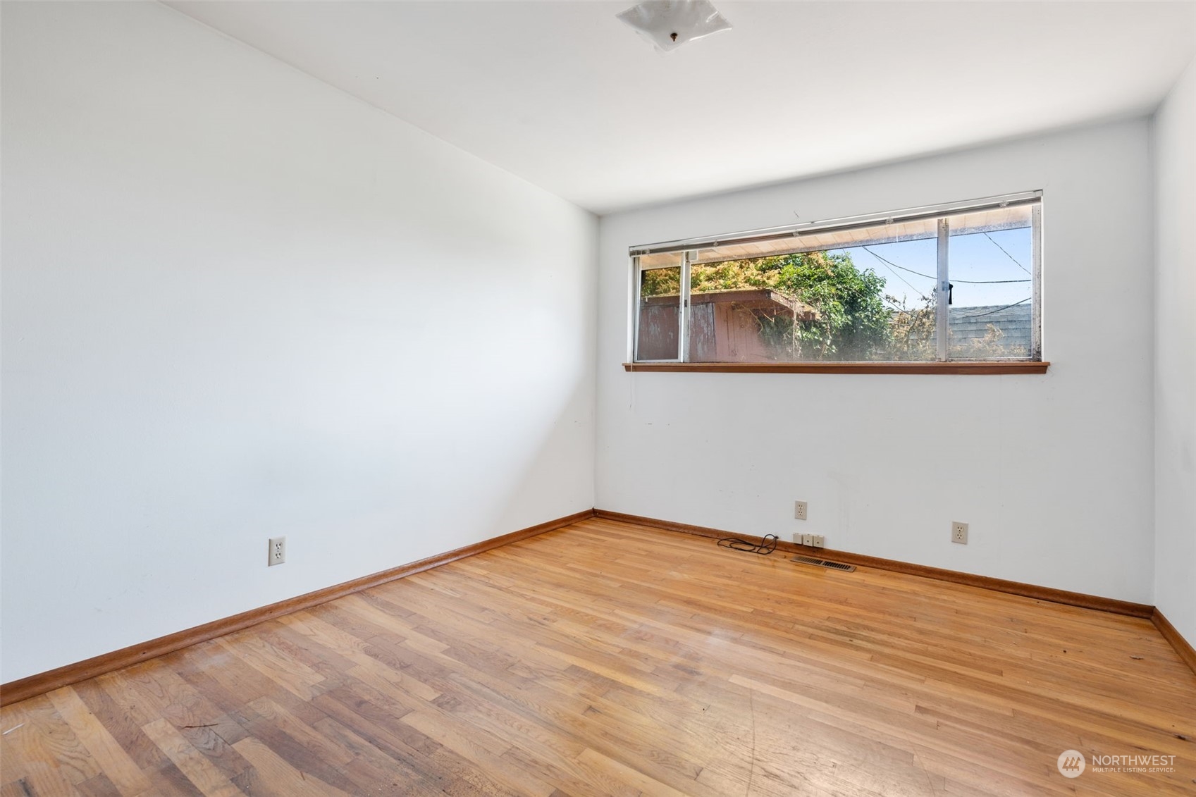 7634 South 112th Street Seattle, WA 98178 - Photo 14 of 26 an empty room with wooden floor and a window
