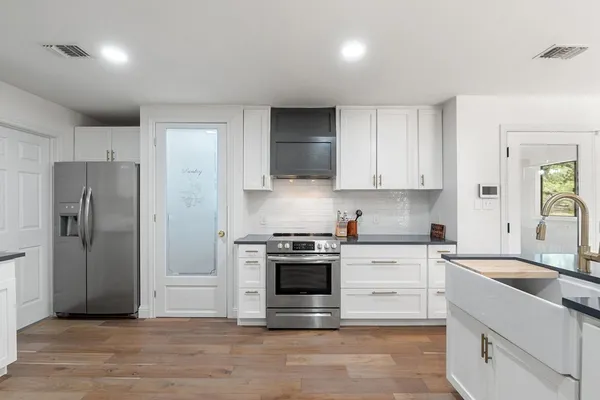 a kitchen with stainless steel appliances granite countertop a stove a refrigerator and a sink