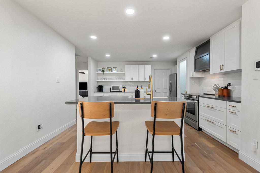201 Raincloud Road Wimberley, TX 78676 - Photo 17 of 40 Kitchen featuring dark countertops, white cabinets, stainless steel appliances, extractor fan, and open shelves