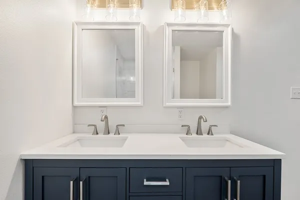 a bathroom with a sink and two mirror