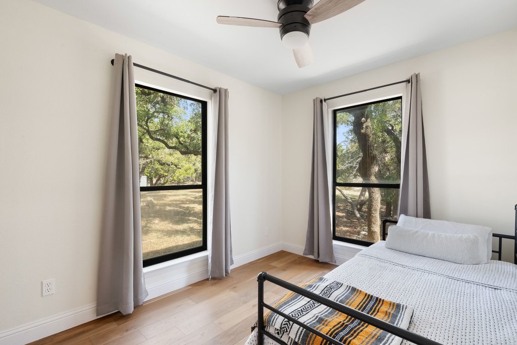 201 Raincloud Road Wimberley, TX 78676 - Photo 27 of 40 Bedroom with light wood finished floors, multiple windows, and a ceiling fan