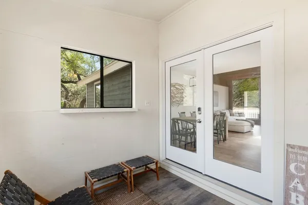 a view of a hallway with bathroom view and wooden floor