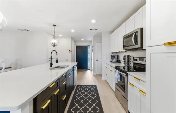 a kitchen with stainless steel appliances a sink stove and refrigerator