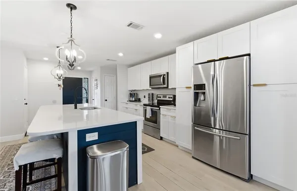 a kitchen with stainless steel appliances a refrigerator sink and microwave